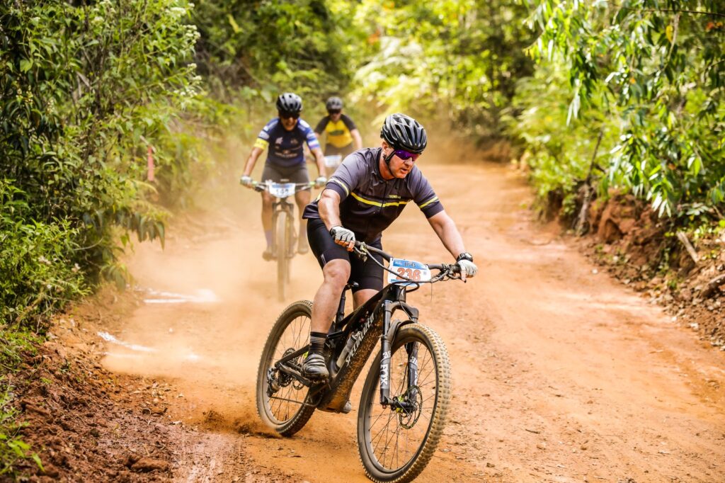 several cyclists cycling on a dirt trail