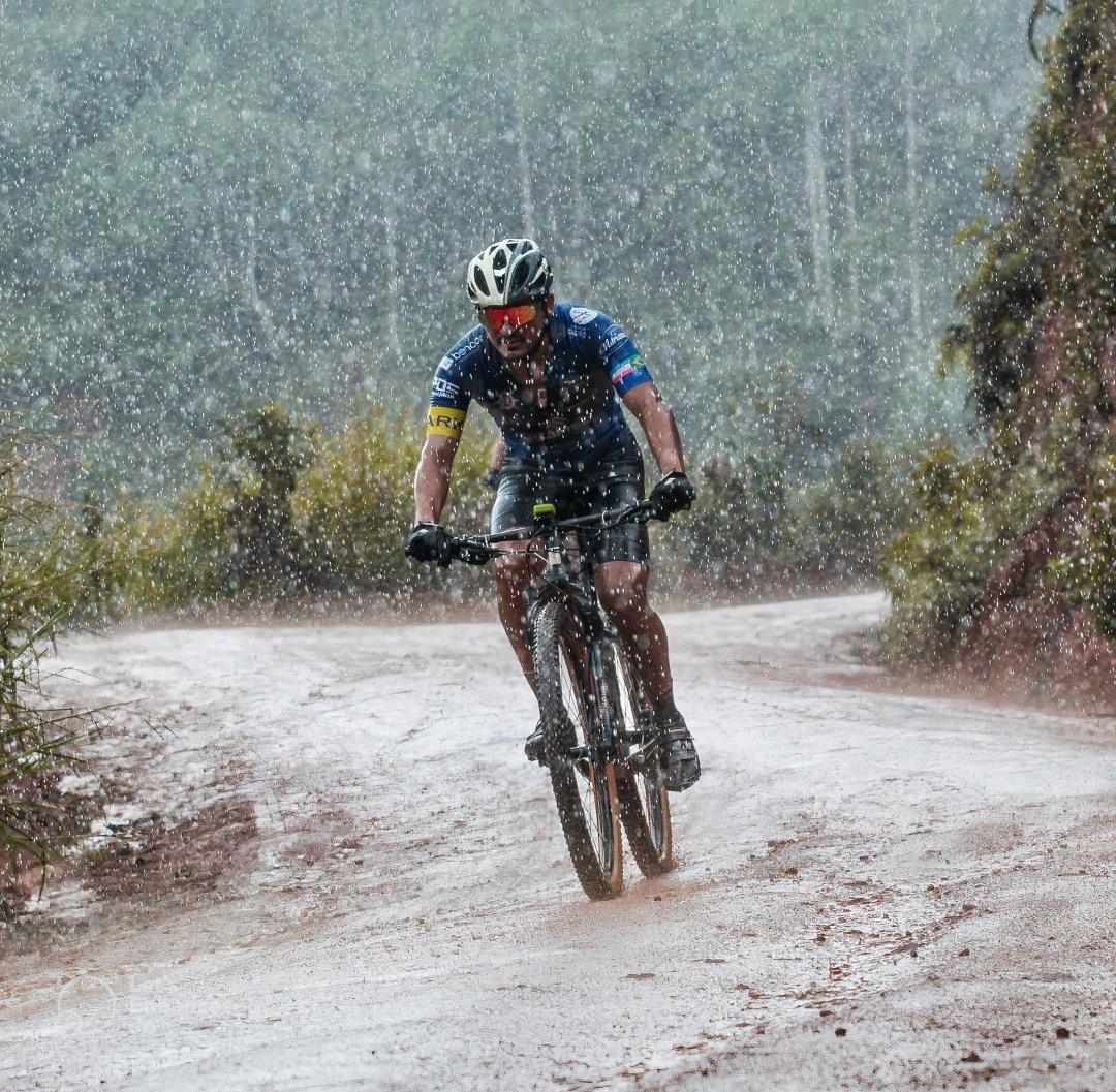 Cyclist cycling on a dirt path in the rain