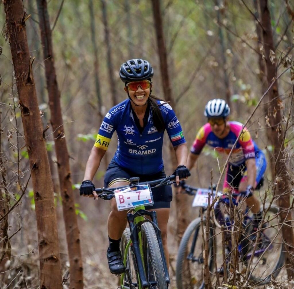 Female cyclist pedaling on dirt path