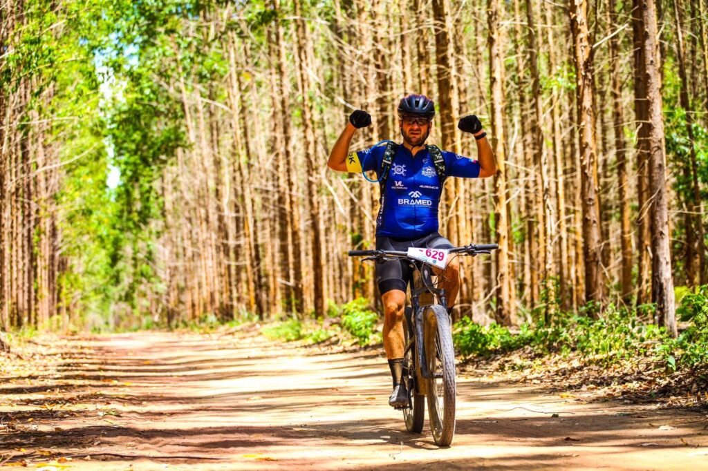 shark team cyclist pedaling with arms raised